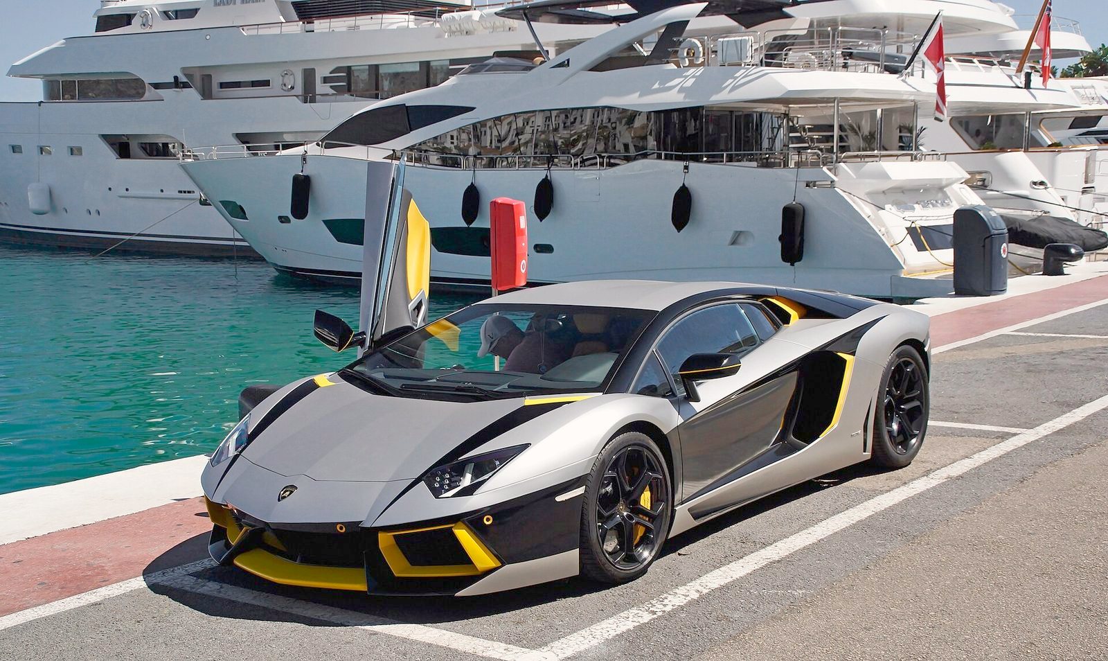A Lamborghini beside the superyachts